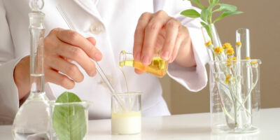 the scientist,dermatologist testing the organic natural product in the laboratory.research and development beauty skincare concept.blank package,bottle,container .cream,serum.hand